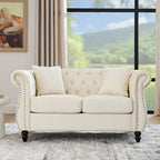 Canapé Chesterfield deux places en velours beige, accoudoirs arrondis, garniture cloutée