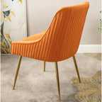 Fauteuil luxueux en velours avec dossier incurvé élégant, pieds en métal doré et revêtement doux pour une assise confortable.